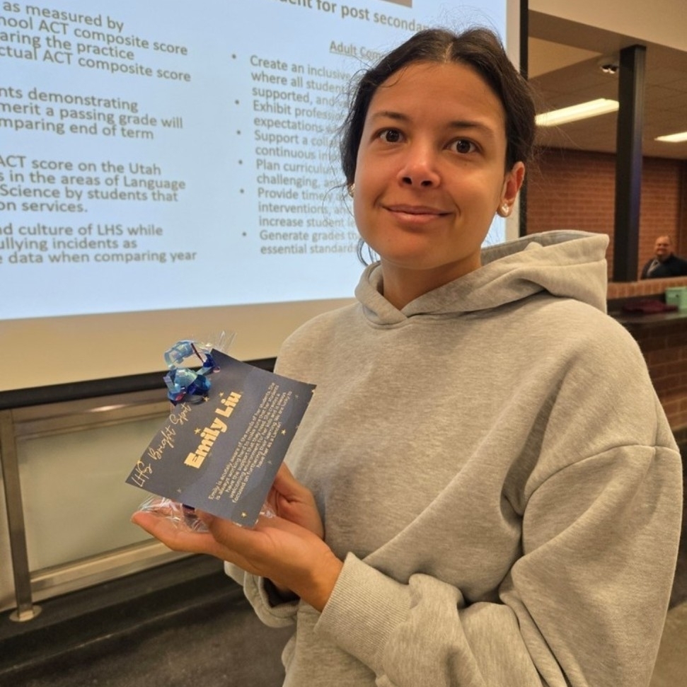Mrs. Liu holding her Bright Spot award.