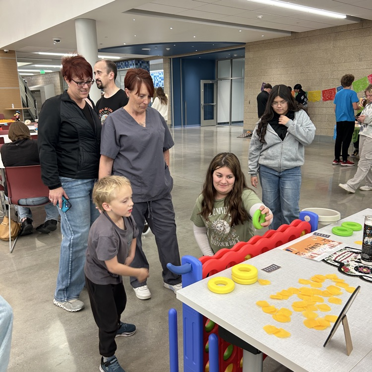 Adults and students watch a young boy playing a game