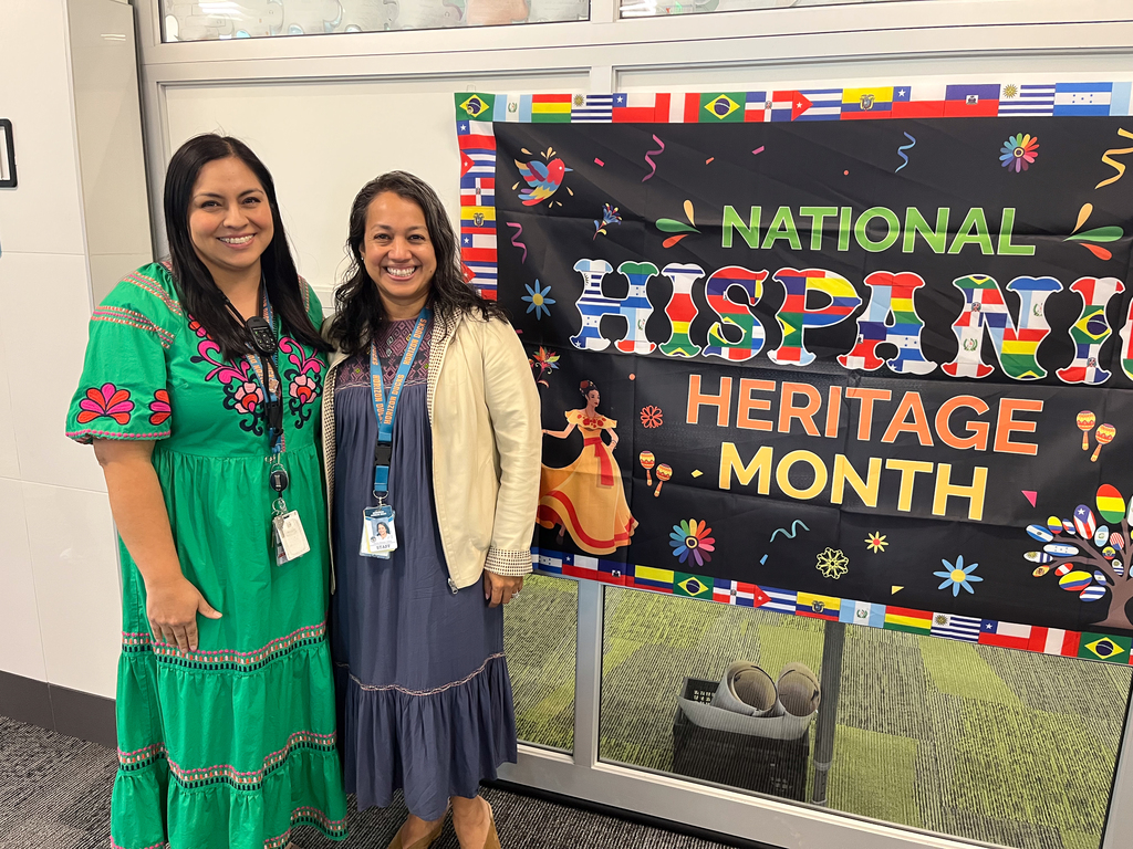 Two teachers smiling at the camera.