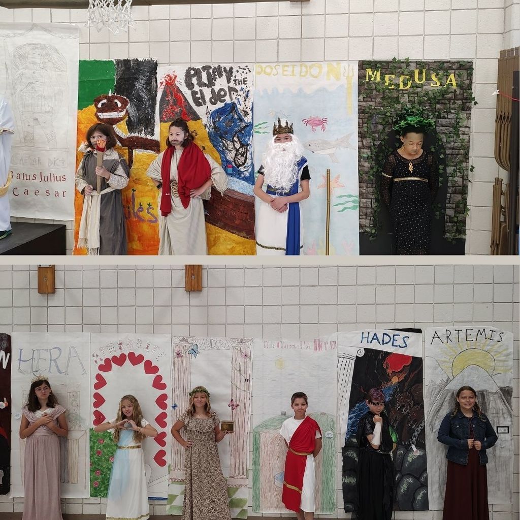 Students dressed as ancient characters with decorated backgrounds.