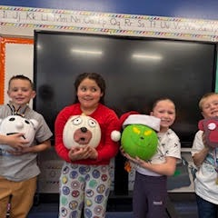 4 students hold decorated pumpkins