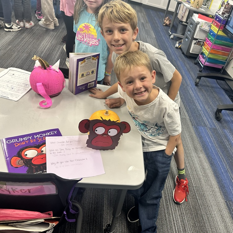 two boys smiling behind a monkey pumpkin with the book grumpy monkey next to it