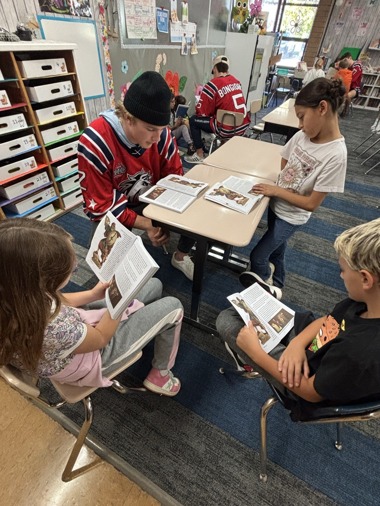 students reading with Ogden Mustang hockey team.