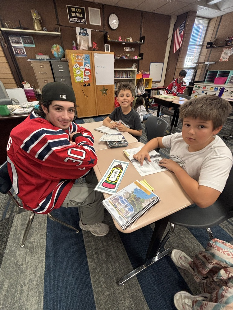 students reading with Ogden Mustang hockey team.