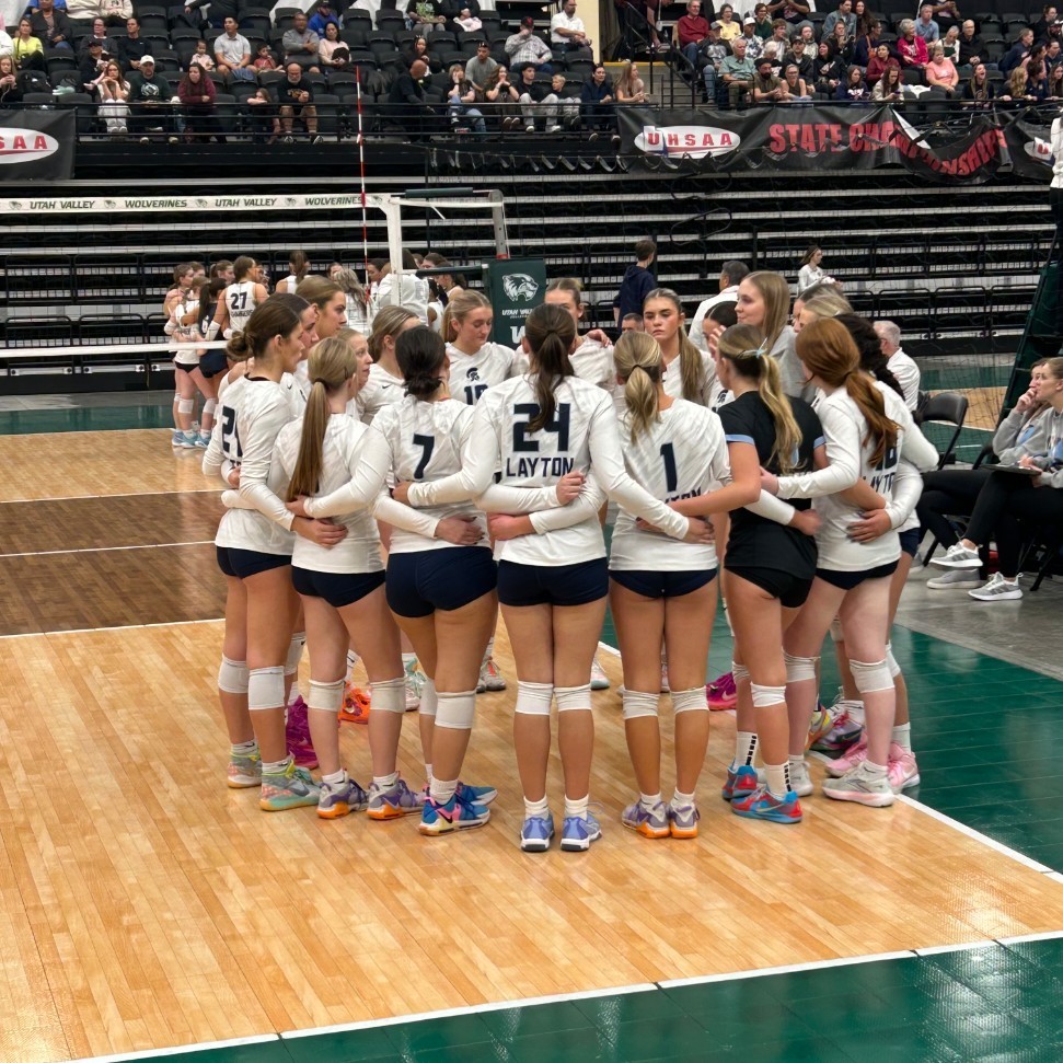 volleyball players in a circle with arms around each other