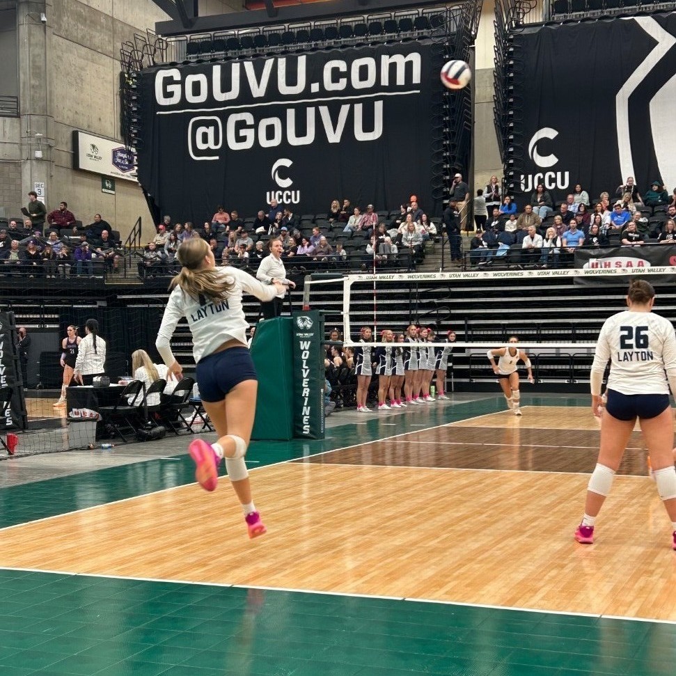 A lancer volleyball player with a great hit over the net
