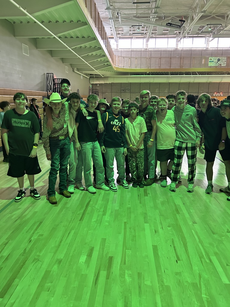 Young men standing in the gym under a green light.