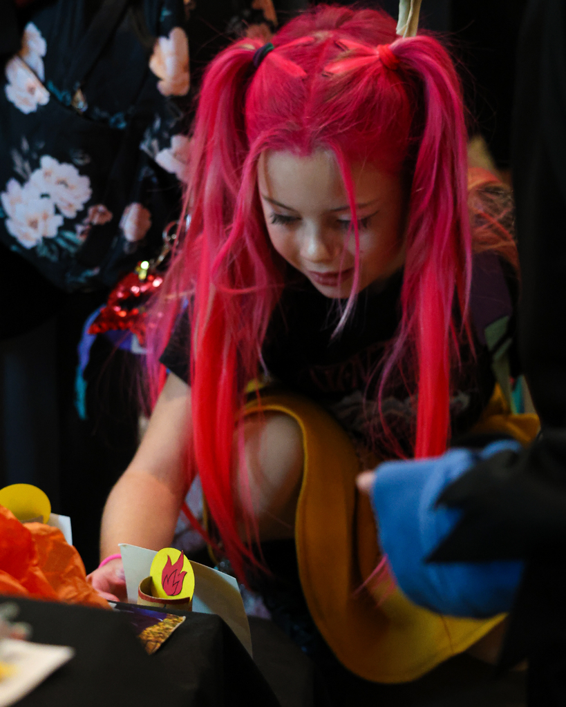 A student puts a photo onto the ofrenda at Canyon Creek Elementary.