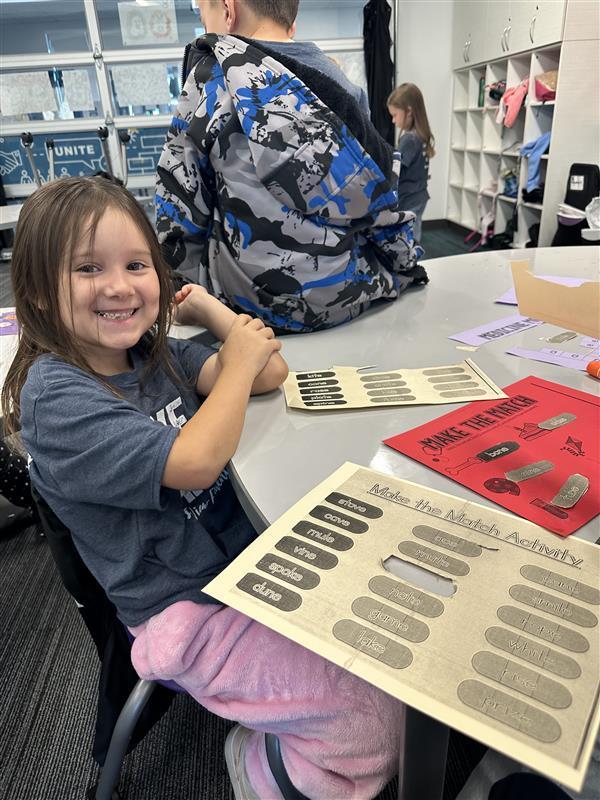 brunette girl smiles at camera as she works on making the match activity
