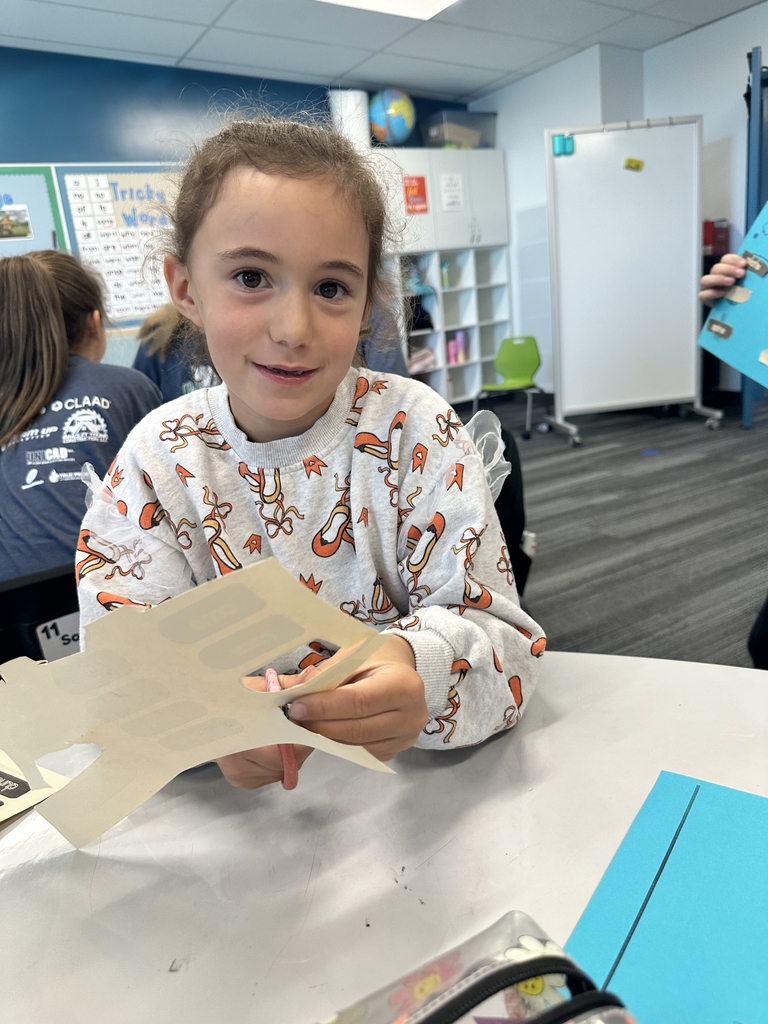 girl cutting papers while smiling