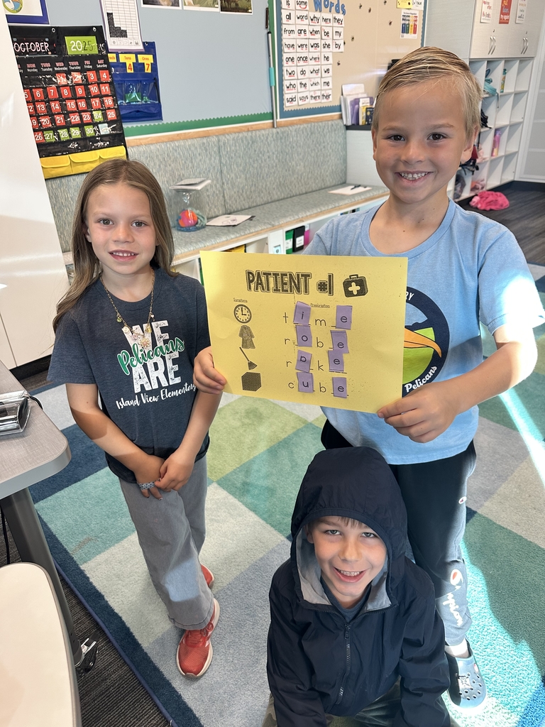 2 boys and a girl smiling while holding patient #1 paper