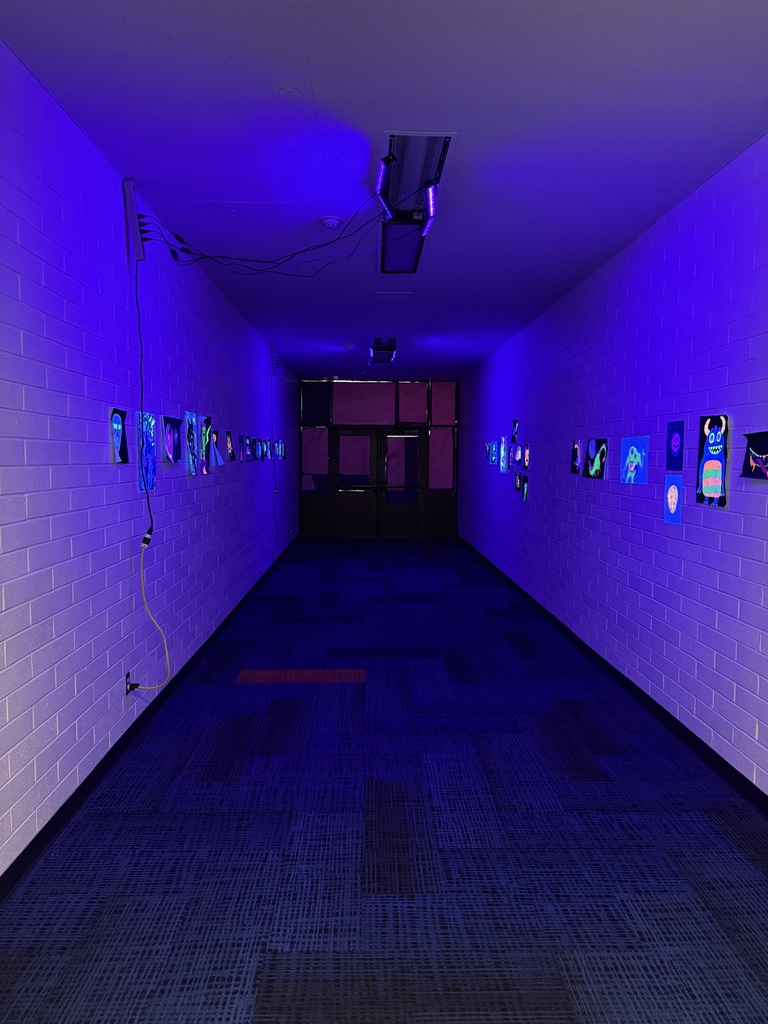 Mr. Colton's art class showing off their blacklight art pieces