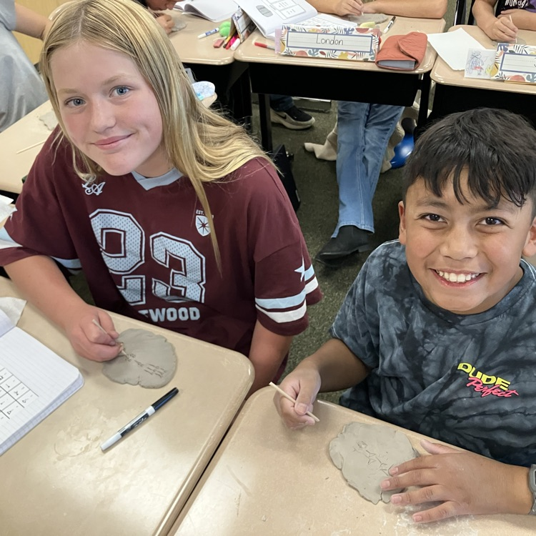 students carving names into clay