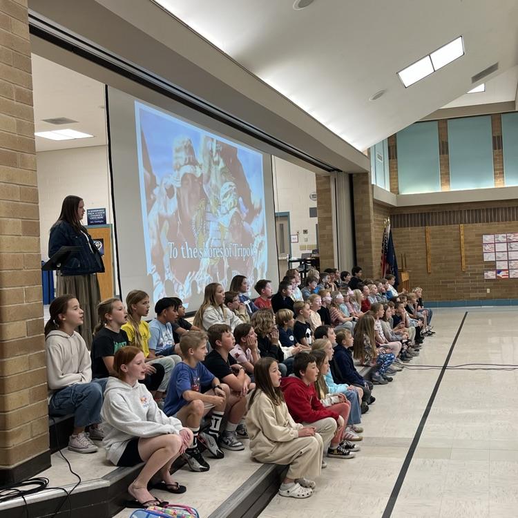 students can be seen singing, and preparing for the Veterans Day program on our stage.