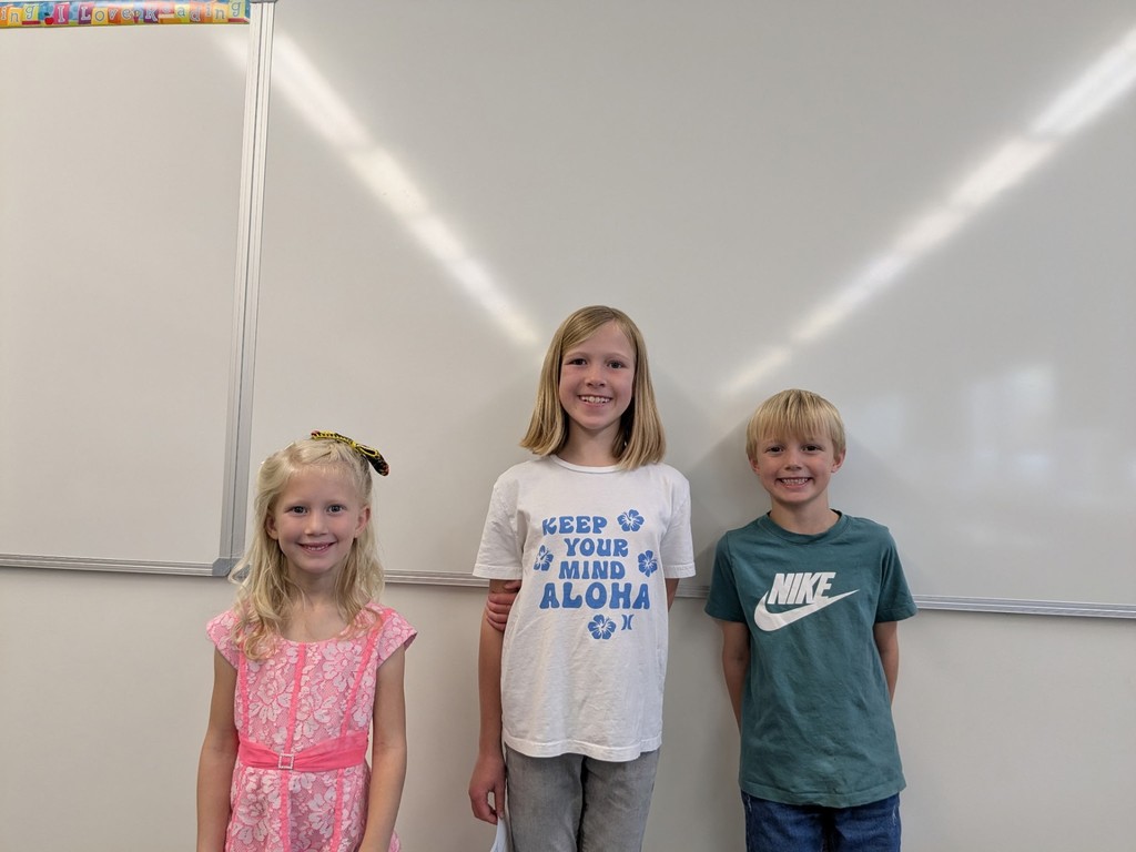 Students standing in front of a white board smiling