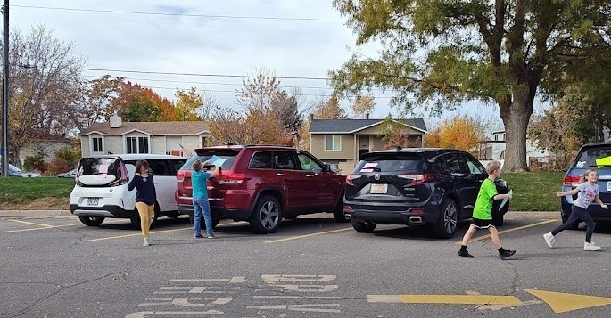 Students placing kind notes on cars.