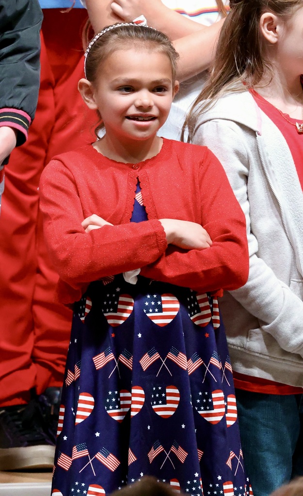 A student smiles with her arms folded while wearing a flag dress. 