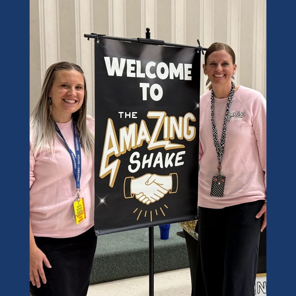 Teachers standing next to a sign that reads Welcome to the Amazing Shake.