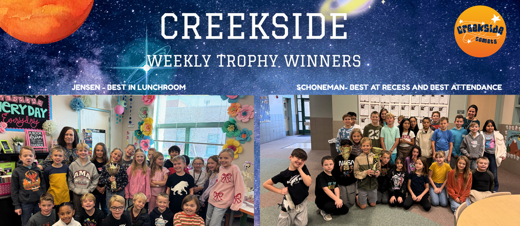Students in classroom with teacher holding trophy for best at