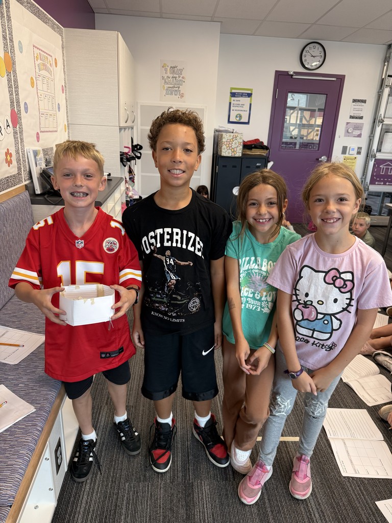 2 boys and 2 girls with a paper home