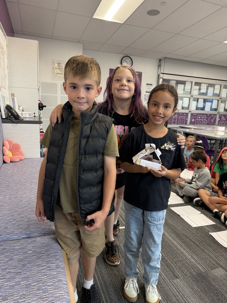 a boy and two girls holding a paper home