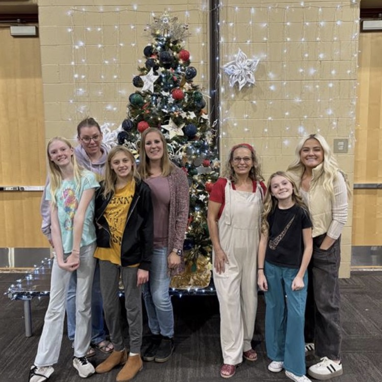 students and teacher posing with tree