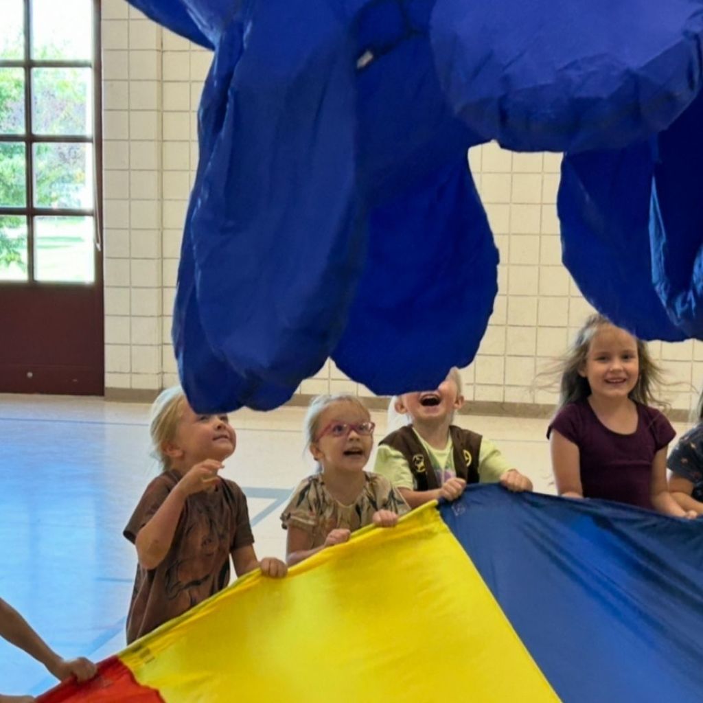 Students in PE playing with a parachute and a giant octopus.