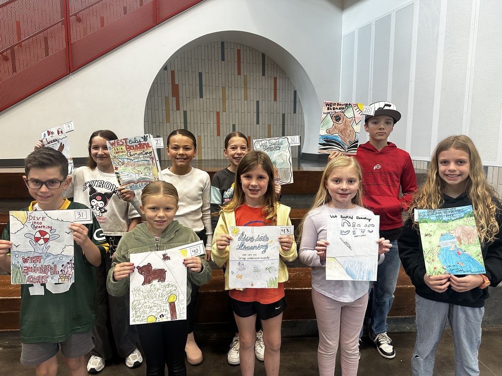 Winners for the back of the yearbook cover contest. 9 students holding their yearbook cover art. 