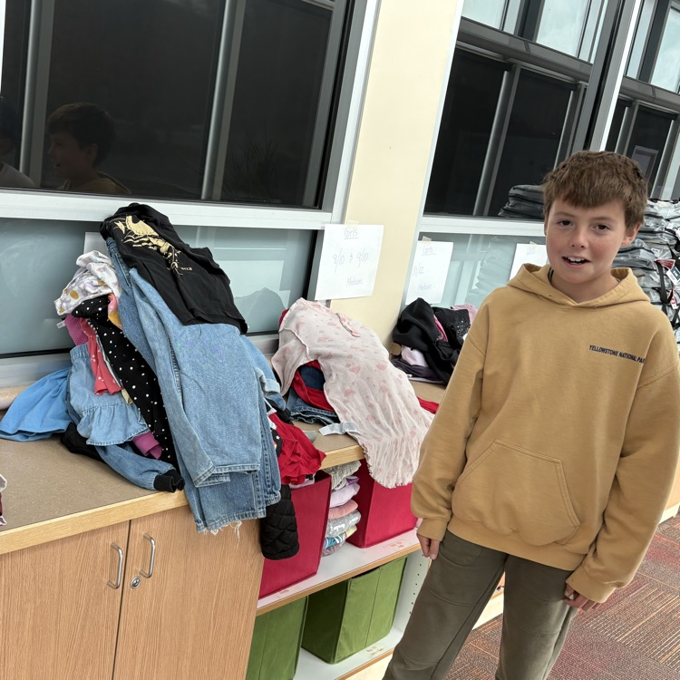 A student standing next to a pile of clothes