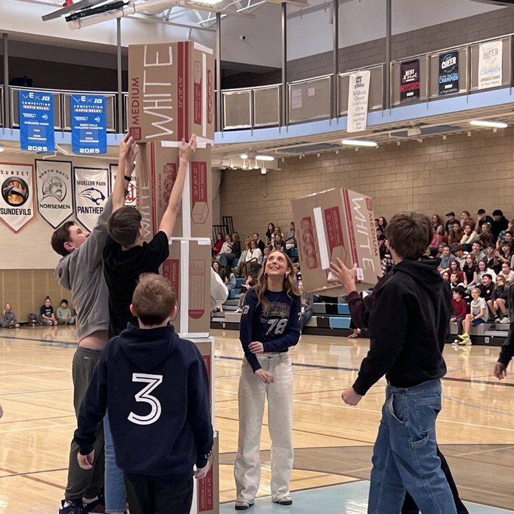 Students working together to stack boxes.