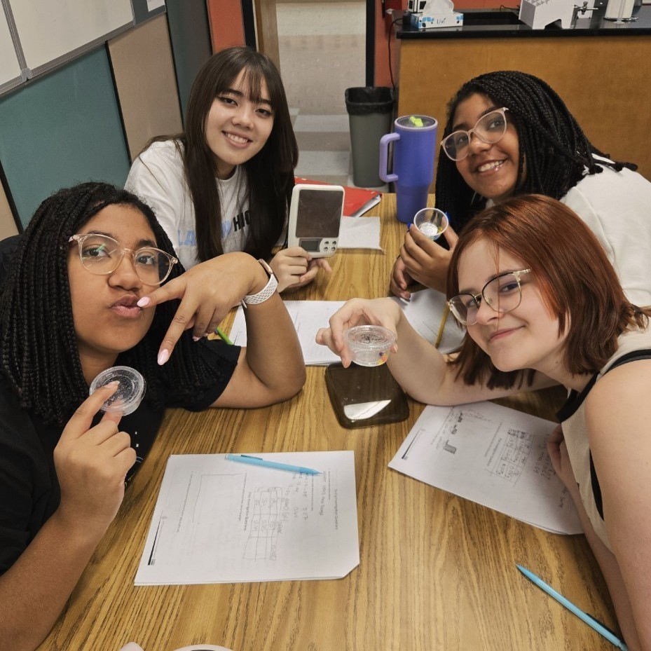 four female students smiling for the camera after finishing their lab work