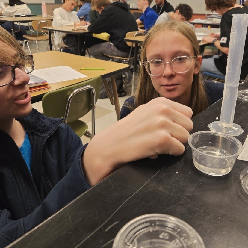 two students working on their lab measuring liquid