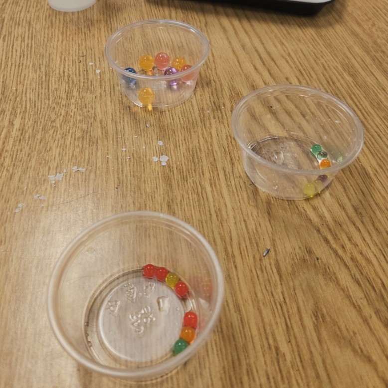 three small cups with different sizes of orbeez in them