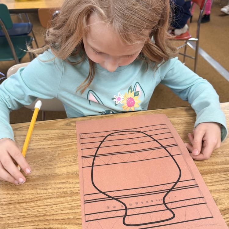 student drawing designs on vase for Greek civilization art project