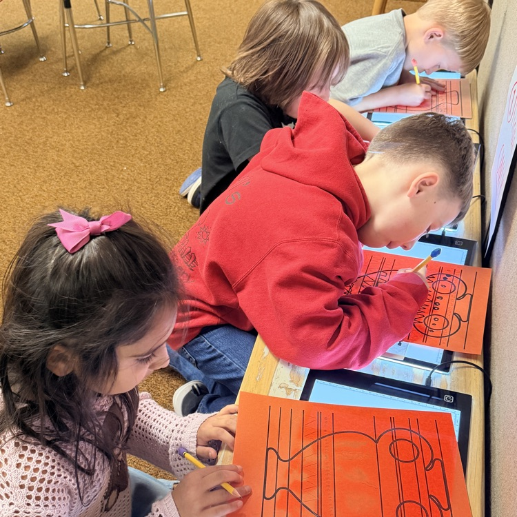 student drawing designs on vase for Greek civilization art project