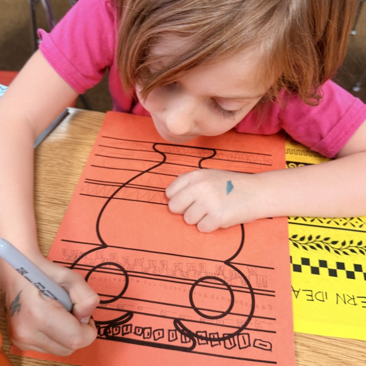 student drawing designs on vase for Greek civilization art project