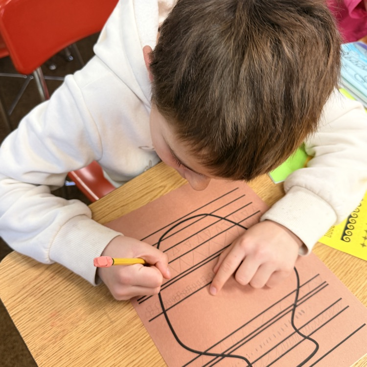 student drawing designs on vase for Greek civilization art project