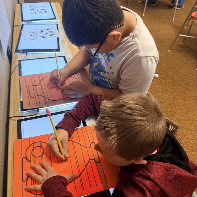 student drawing designs on vase for Greek civilization art project