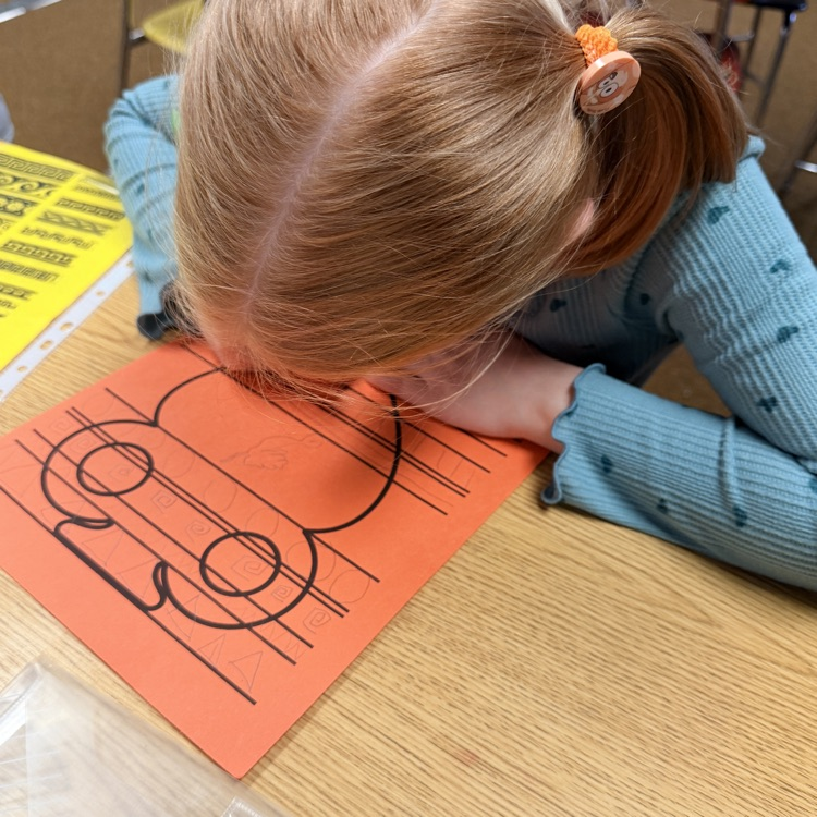 student drawing designs on vase for Greek civilization art project