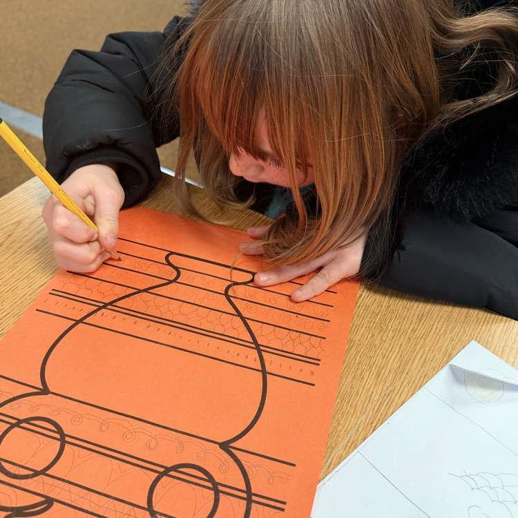 student drawing designs on vase for Greek civilization art project