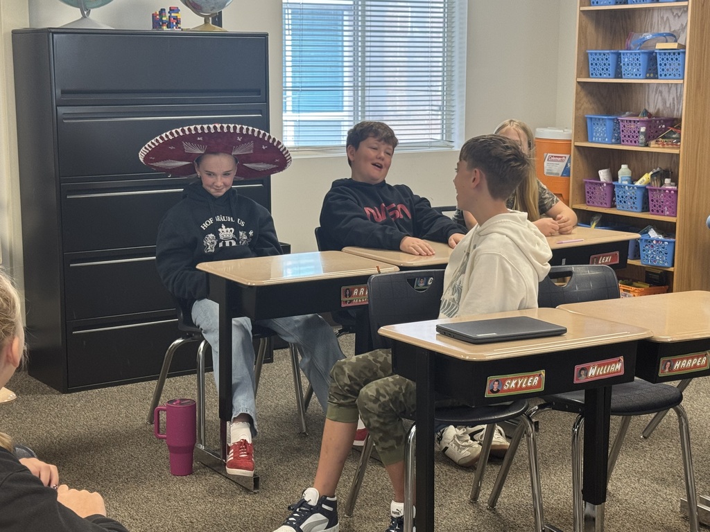 student in sombrero with other students singing
