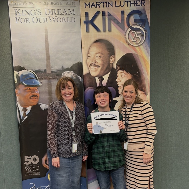 A 4th grade student with Mrs. Morrell and Ms. Swinyard with his certificate from the Martin Luther King Jr speech competition.