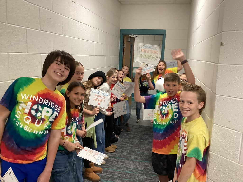 Kids standing in a crowd with signs in a doorway