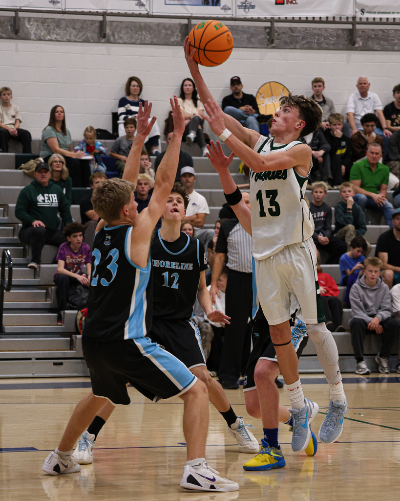 A Farmington Junior High player jumps above Shoreline players to get the ball into the basket at the Davis School District Boys Basketball Championship Game. 