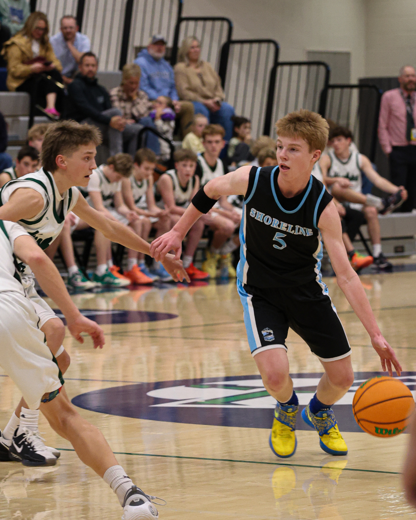 A Shoreline Junior High player moves past a Farmington Junior High player at the Davis School District Boys Basketball Championship Game. 