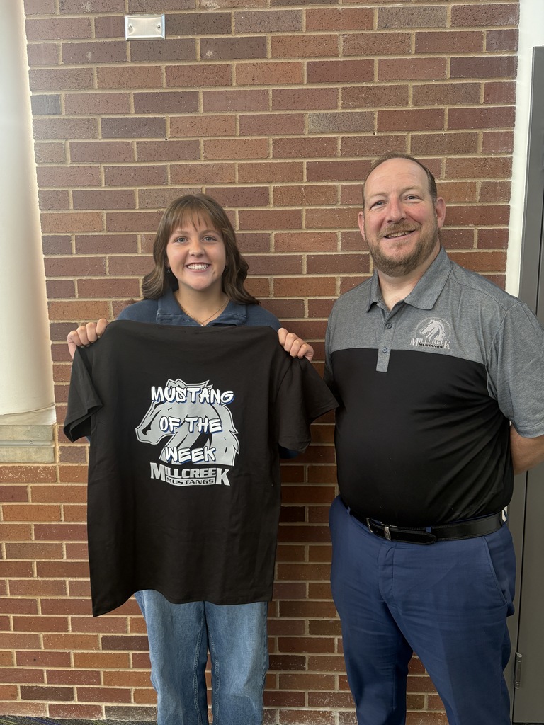 An image of our Mustang of the week and our principal, Mr. Hansen. Student is holding a black shirt with the Mustang logo and the words "Mustang of the Week"