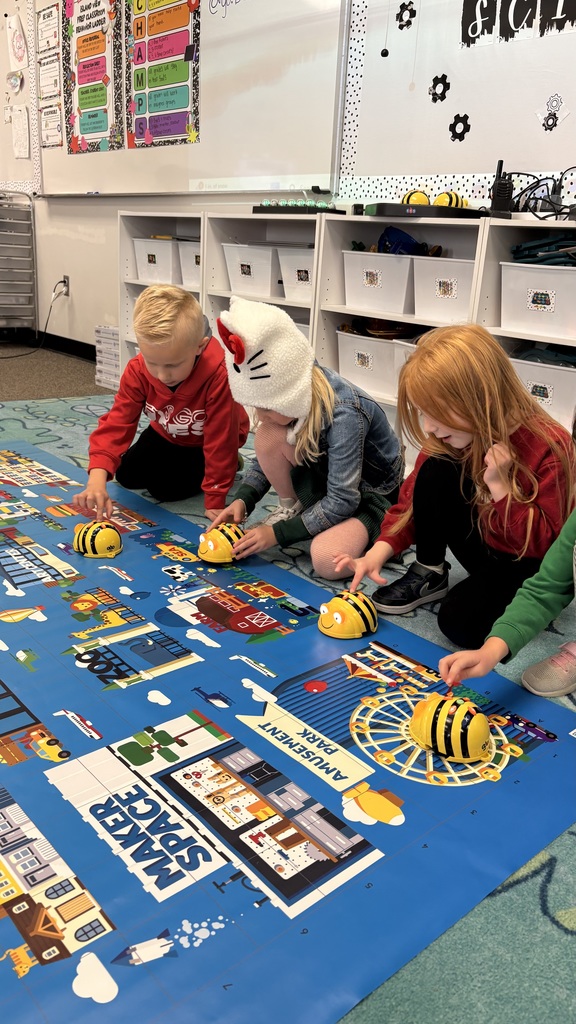 4 students pressing buttons on robotic bees