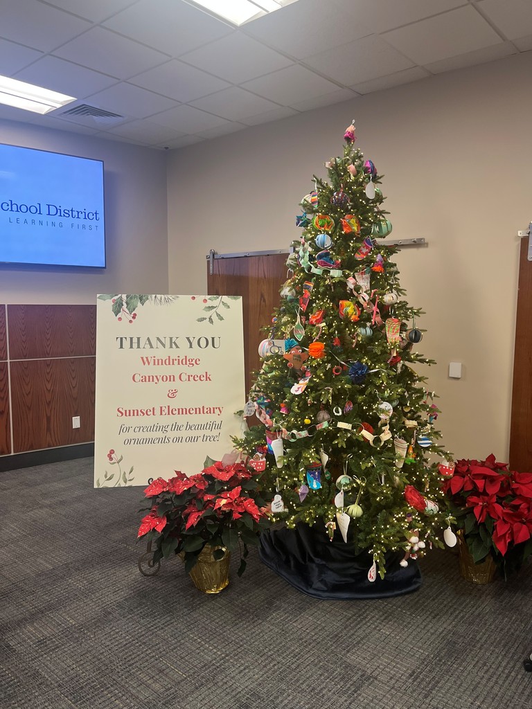 Decorated Christmas tree with a sign next to it that says, "Thank You Windridge, Canyon Creek, and Sunset Elementary for creating the beautiful ornaments on our tree!