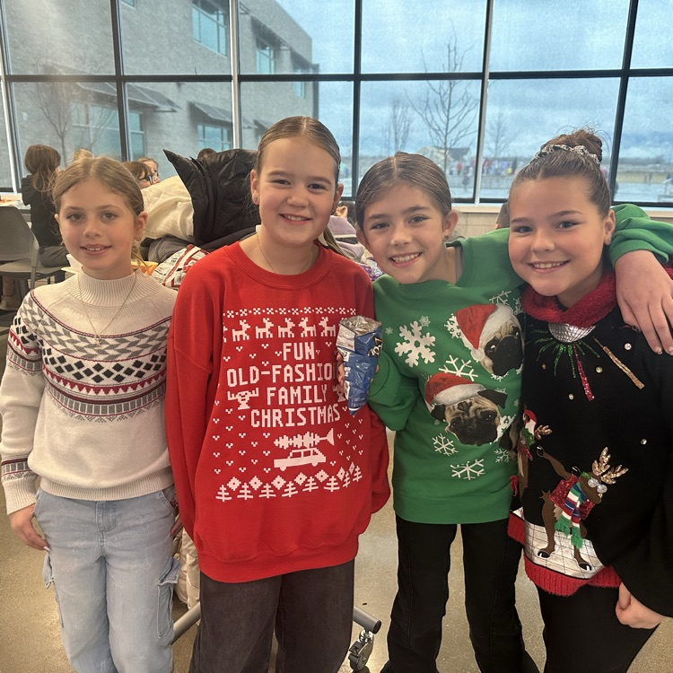 4 Girls smiling with Christmas sweaters on