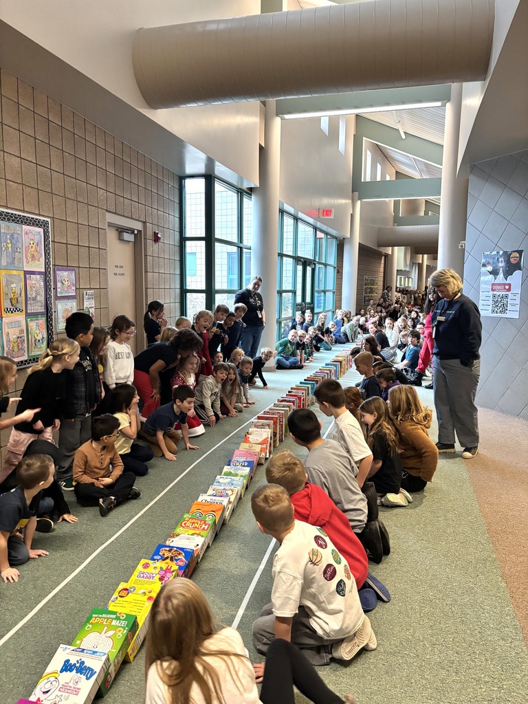 students sitting in the hallway watching ceral boxes tumble like dominos
